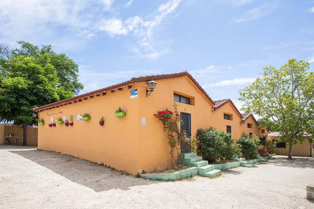 Edificio del albergue con jardineras y escalera de entrada