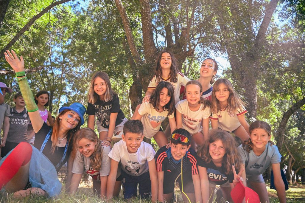 Grupo de niños y niñas posando en el campo durante una actividad en el Albergue Sierra Norte