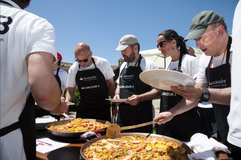 Equipo de una empresa cocinando paellas en una jornada de team building en la finca