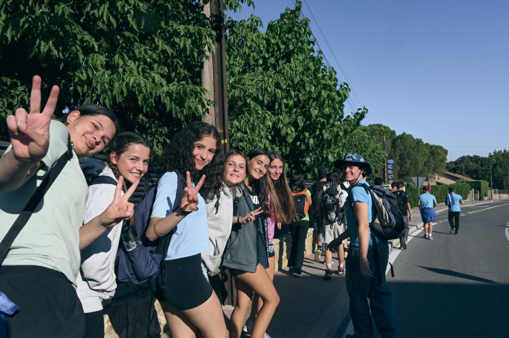 Grupo de chicas y chicos haciendo el signo de la victoria durante una excursión de un viaje de fin de curso
